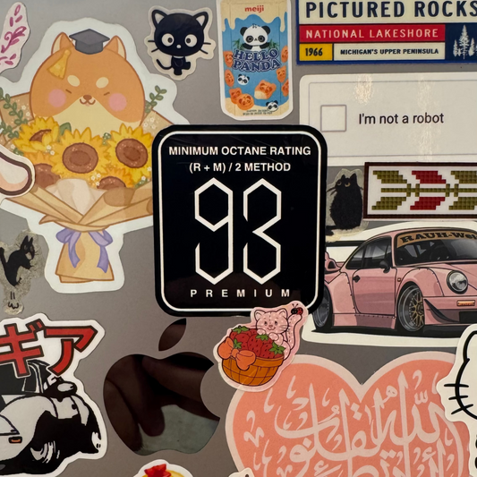 Collection of various stickers on a surface, including a prominent '93' sticker.