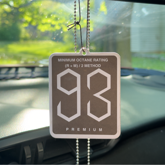 93 octane rating car air freshener hanging from a car's rearview mirror.