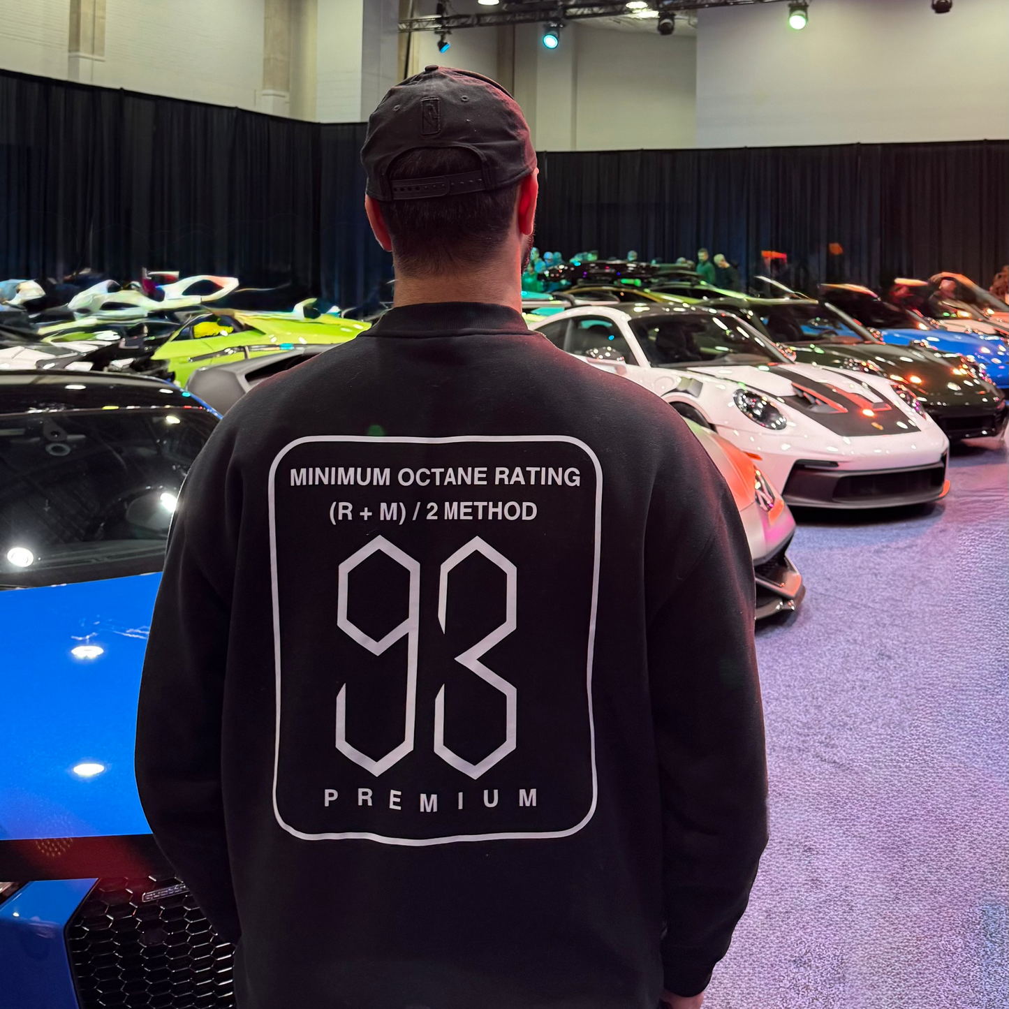 Person wearing a black hoodie with a car design at a car show